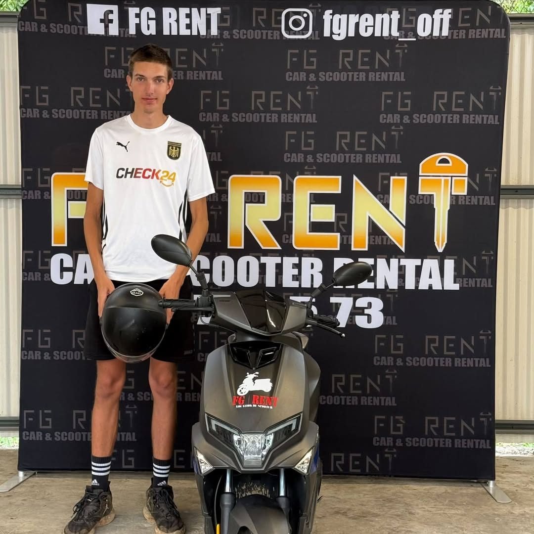 Jeune client tenant son casque devant le mur FG Rent et un scooter noir